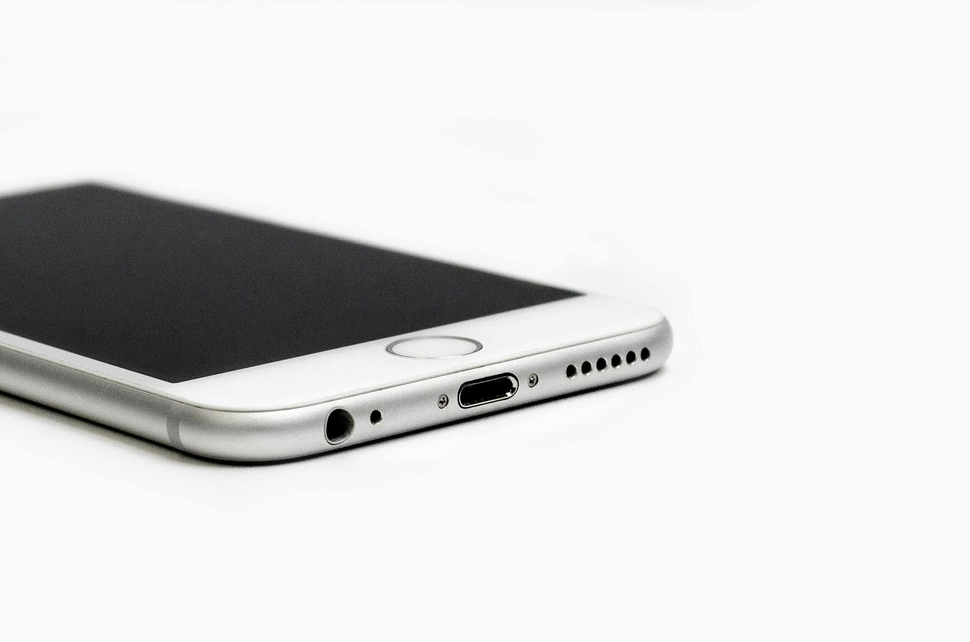 Close-up of the bottom edge of a smartphone showing the charging port, headphone jack, and speakers.